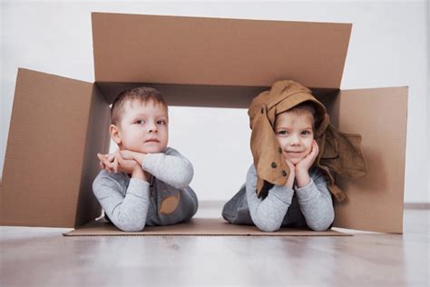 Dos Niños Un Niño Y Una Niña Jugando En Cajas De Cartón Foto Del