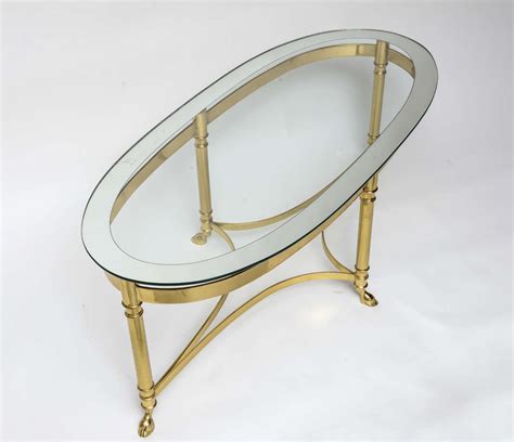 This is a mid c20th brass and glass top coffee table. Oval Brass Coffee Table with Mirrored Rim Glass Top at 1stdibs