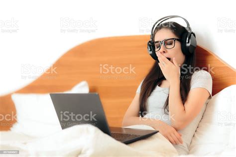 Yawning Sleepy Woman With Headphones And Laptop Stock Photo Download