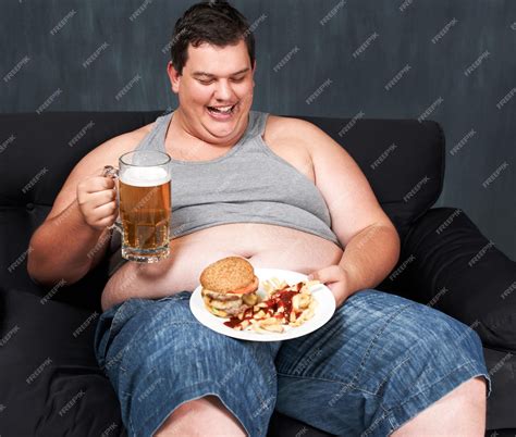 Premium Photo Something To Wash Down His Meal An Obese Young Man