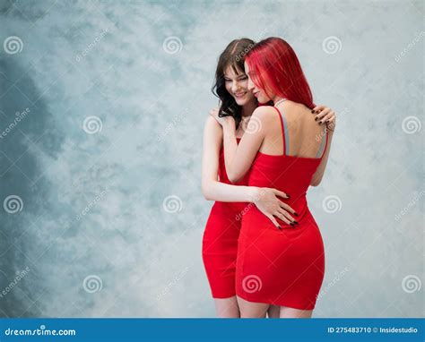 A Close Up Portrait Of Two Tenderly Embracing Women Dressed In