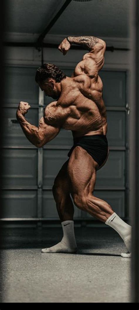 A Bodybuilding Man In Black Shorts And Socks Is Doing A Kickbox Pose