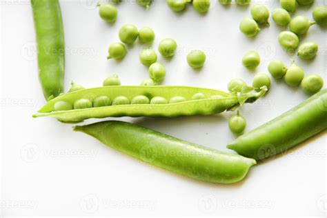Pods Of Fresh Green Peas And Green Scattered Peas 10305260 Stock Photo