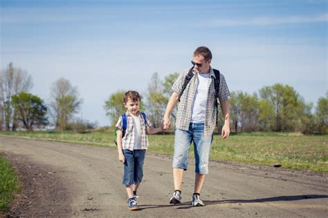 Father And Son Walking On The Road At The Day Time Stock Photo Image