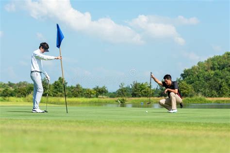 Golfer Man And Friend Playing Golf Aiming Shot For Putting Ball On The