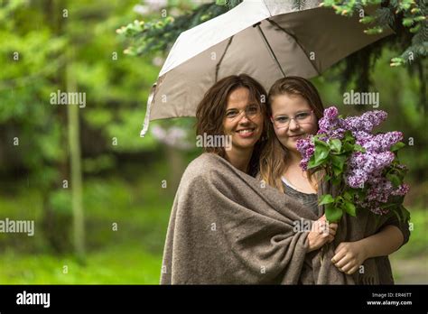 Mother With Her Daughter In The Park In The Rain Together Under An