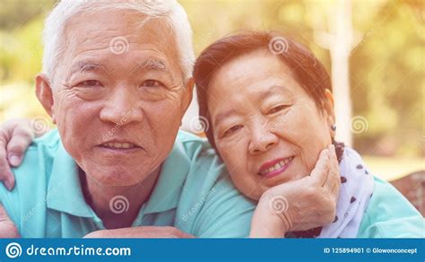 Close Up Face Happy Eldery Asian Couple Smile Together In Green Stock