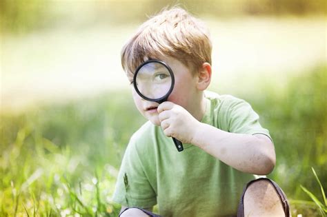 Portrait Of Boy Looking Through Magnifying Glass Stock Photo