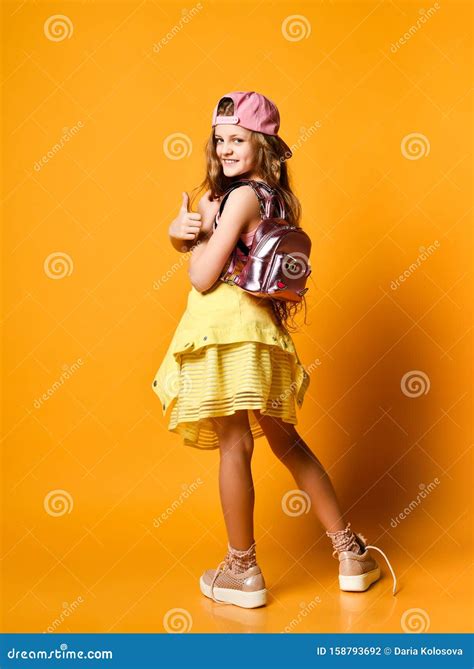 Retrato Interior De Una Adolescente Con Falda Amarilla Zapatillas Y Una Gorra Con Una Mochila