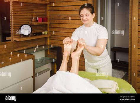 masseur woman doing traditional foot massage beautiful model enjoying a treatment in a spa