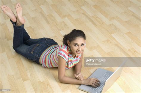 Portrait Of A Young Woman Lying On The Floor And Using A Laptop Photo