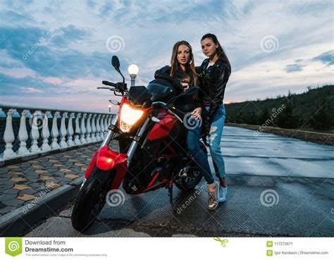 Deux Filles De Motard Dans Des Vestes En Cuir Sur Une Moto De Sport De