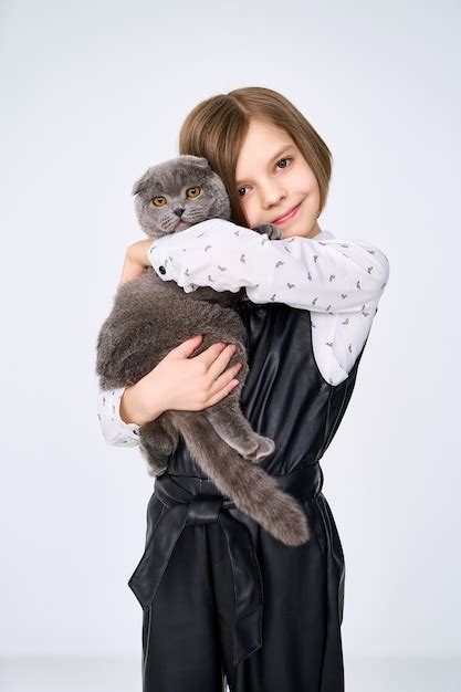 Premium Photo Caucasian Little Girl Holds Her Cat In The Arms