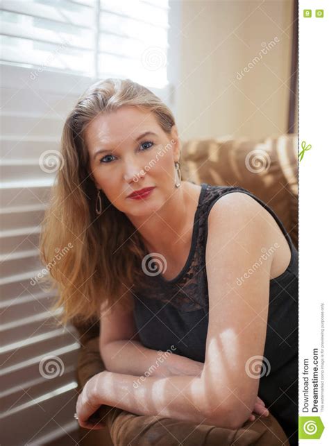 Closeup Portrait Mature Blonde Female Sitting On Sofa Looking At Camera Stock Image Image Of