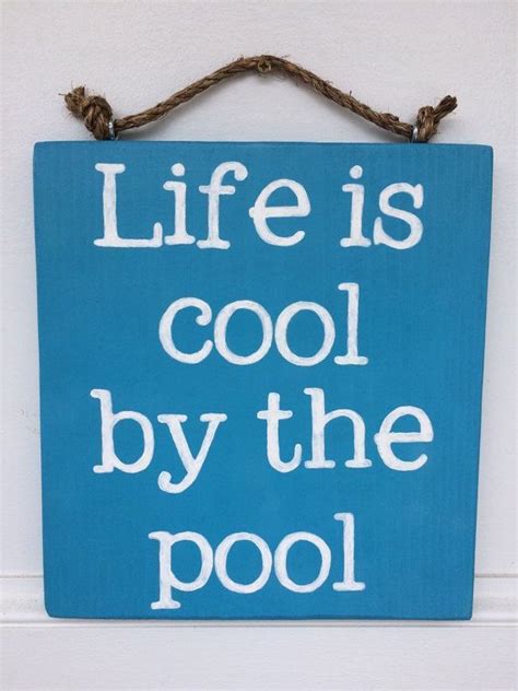 A Blue Sign That Says Life Is Cool By The Pool Hanging On A White Wall
