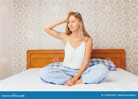 une jeune fille s assied dans les pyjamas sur le lit dans sa chambre et le p photo stock