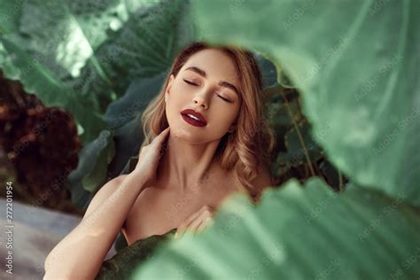 Beauty Face Woman Model With Bright Makeup And Healthy Skin Behind Green Leaf Plant Portrait