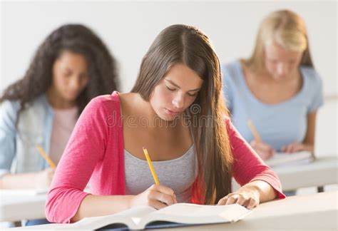 Teenage Students Writing In Book At Desk Stock Image Image Of College