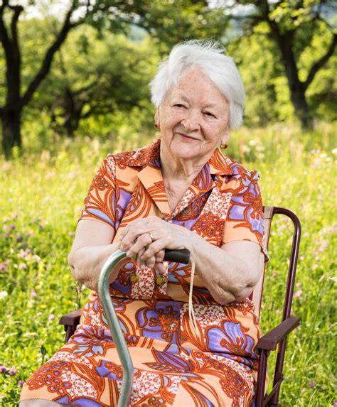 Old Woman Sitting On A Chair With A Cane Stock Photo Image Of Face