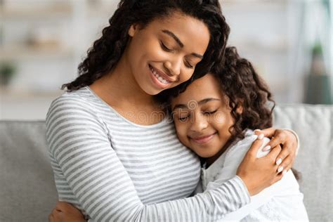 Closeup African Daughter Embracing Mother Sitting Couch Home Stock