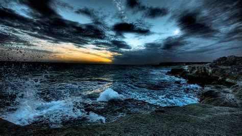 Dark Clouds Under Rough Sea With Brown Rocks During Sunset Time Nature