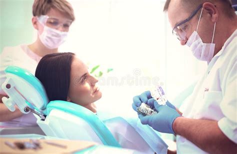 Retrato De Um Dentista Que Trata Os Dentes De Uma Jovem Paciente Foto