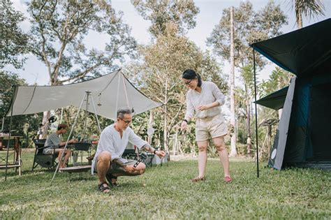Asian Chinese Mature Couple Setting Up Tent And Camp At Woodland Stock