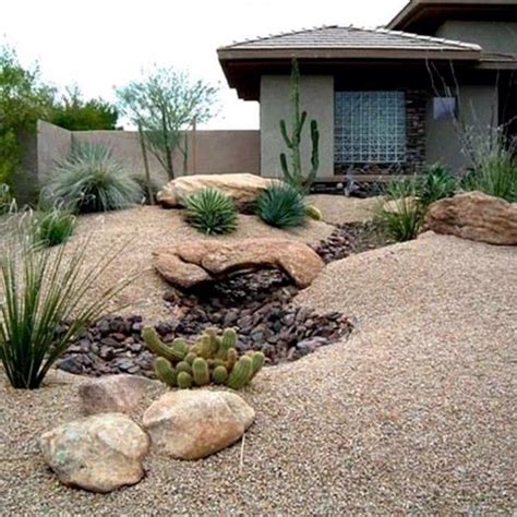 A House With Rocks And Plants In The Front Yard