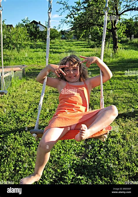 Year Old German Girl In Orange Dress Playing On An Outdoor Swing