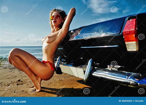 Het Naakte Meisje Zit Naast Autocabriolet Op Het Topless Strand Stock