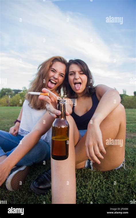 Two Girls Friends Smoking Cigarettes And Drinking Beer