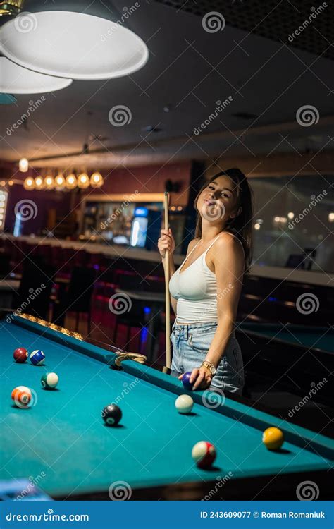 Young Happy Girl Holding Cue And Play Billiard At Pub Stock Image