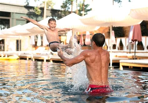 Free Photo Father And Son Enjoying A Day At The Swimming Pool Together