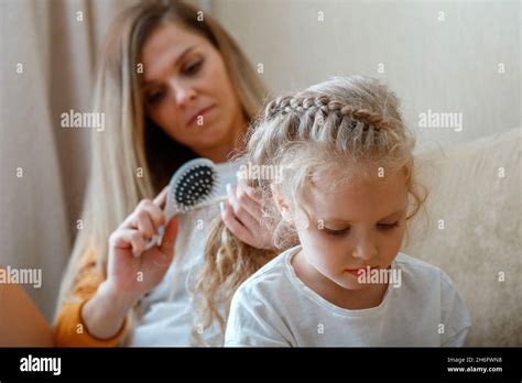 Mother Combing Daughter Long Hair By Hairbrush Caucasian Blonde Mom