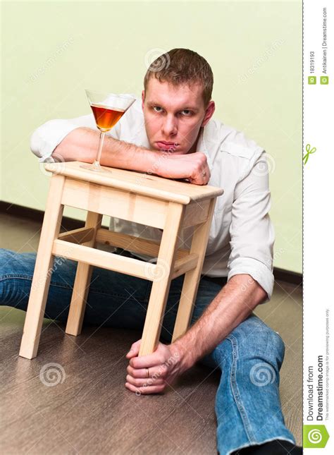 Sirva Sentarse En Suelo Con El Vidrio De Alcohol Imagen De Archivo