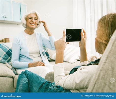 Grandmother Happily Posing For Granddaughter Making Photos Stock Image