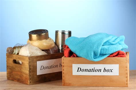 Donation Boxes With Clothing And Food On Blue Background Close U The