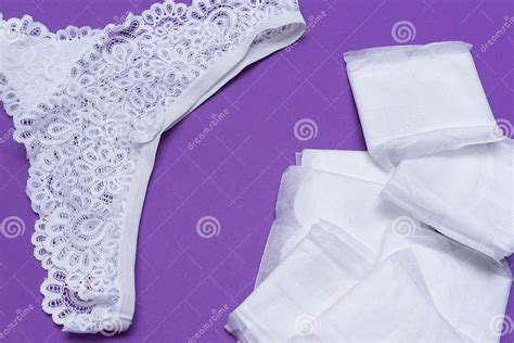 1 Women`s White Lace Panties Sanitary Pads On Purple Background Stock