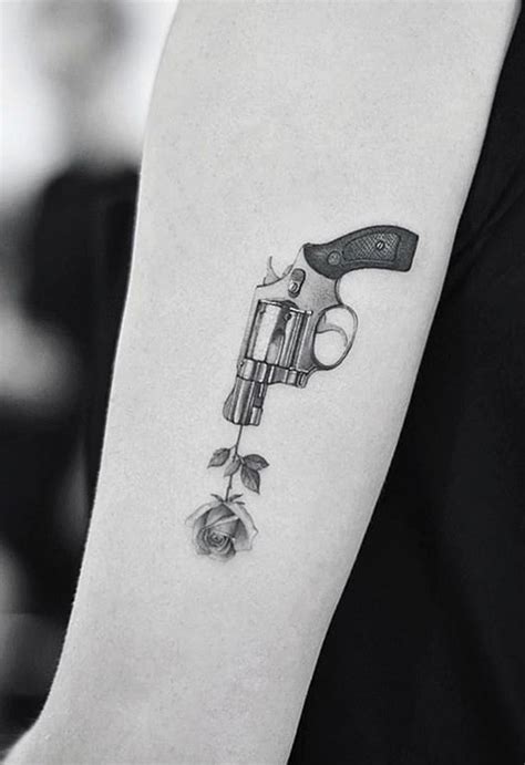 Small rose tattoo behind the ear is very good thinking about getting small tattoo designs. Gun and Rose Tattoo - TattManiaTattMania