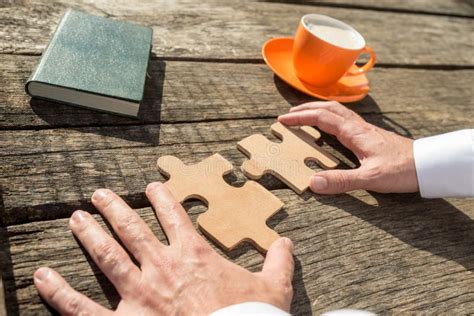 Hands Of A Businessman Holding Two Jigsaw Puzzle Pieces Stock Image