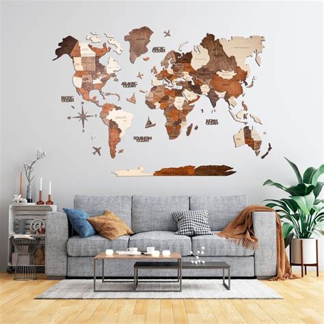 A Living Room With A Grey Couch And Wooden World Map Wall Hanging On