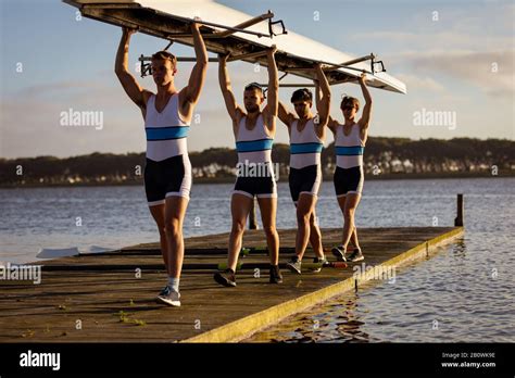 Teammates Carrying The Rowing Boat Together Stock Photo Alamy