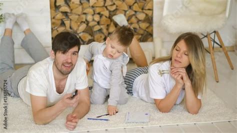 Father Man Mother Watch Tv While Their Son Draw Picture In Their Living