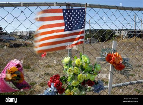 An American flag is seen amid flowers left at the site of a gas