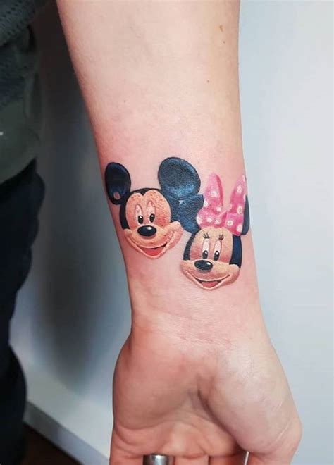 A Person With A Mickey And Minnie Mouse Tattoo On Their Arm