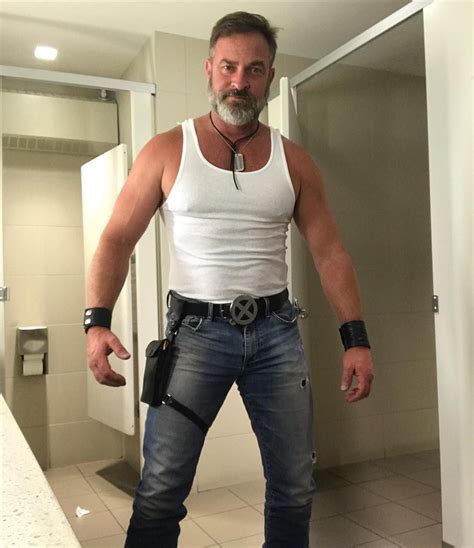 A Man Standing In Front Of A Bathroom Mirror With His Hand On His Hip And Wearing A Leather Belt
