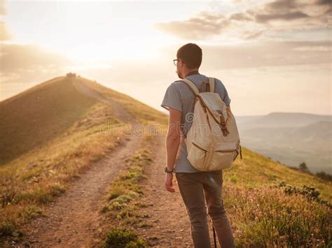 Young Man Travels Alone On The Backdrop Of The Mountains Stock Photo