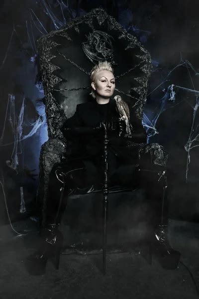 Photo Of A Female Witch Queen Holding Bird And Sitting On A Gothic
