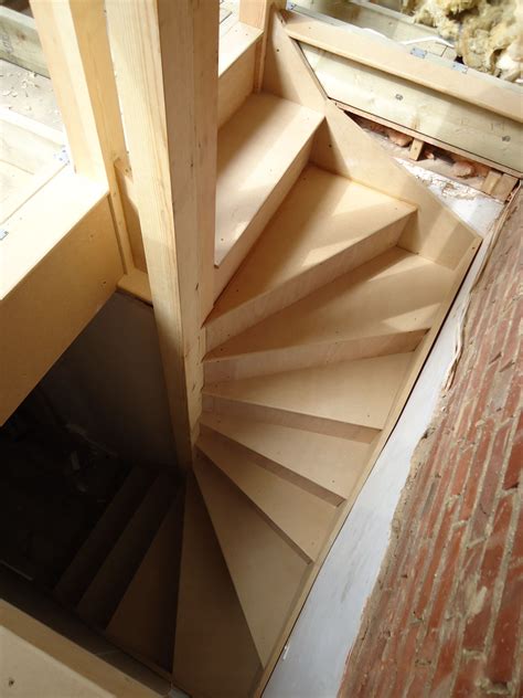 A Spiral Staircase Is Being Built On The Side Of A Brick Wall In An