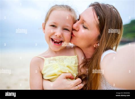 Famille heureuse mère et son adorable petite fille à la plage faire selfies Photo Stock Alamy